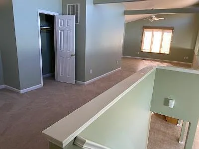 View of upstairs loft from the top of the stairs. Upstairs closet in view and upstairs bathroom is around the corner.