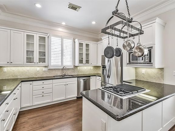 Kitchen with stainless steel appliances and bright white cabinets offers tons of prep and storage space.