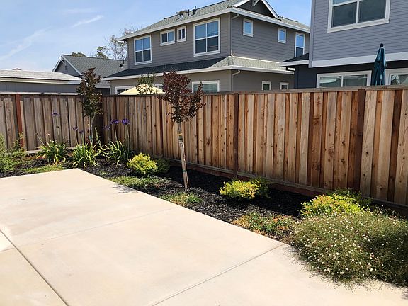 Fenced backyard with back patio
