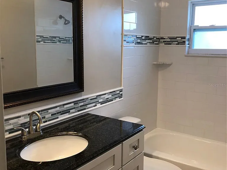 Upscale tiled bath with granite countertop