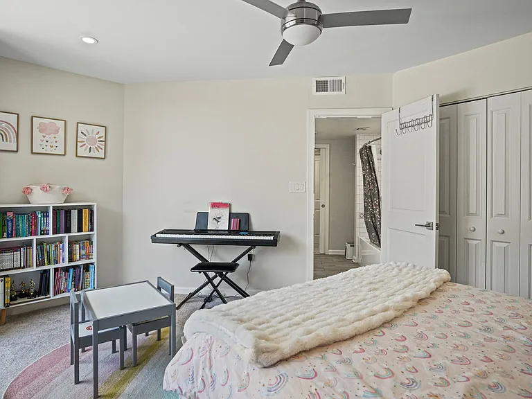 Large, bright secondary bedroom featuring ample closet space and convenient private balcony access