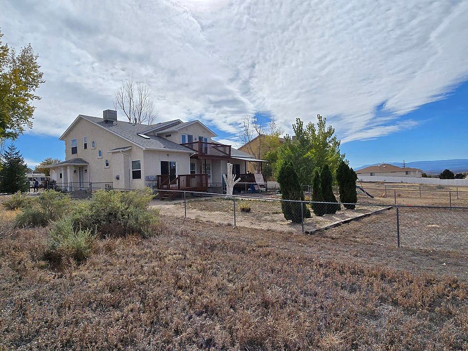 Large fenced back yard with some landscaping.