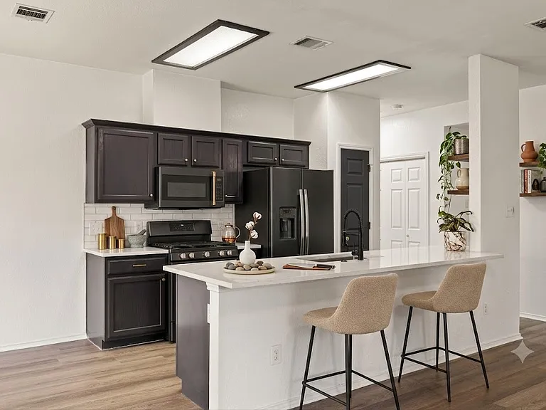 Remodeled open concept kitchen with stainless steel appliance, quartz countertops and subway tile backsplash