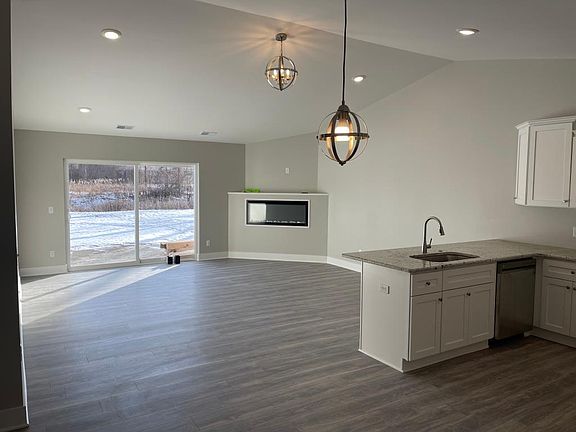 Wide open great room plan, FirePlace shelf for TV cathedral ceiling recessed lights, large door open to private patio and rear yard.