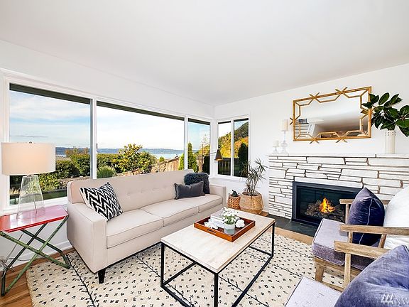 The living room with gas fireplace, beautiful hardwood floors , and large windows to take in the gorgeous views.