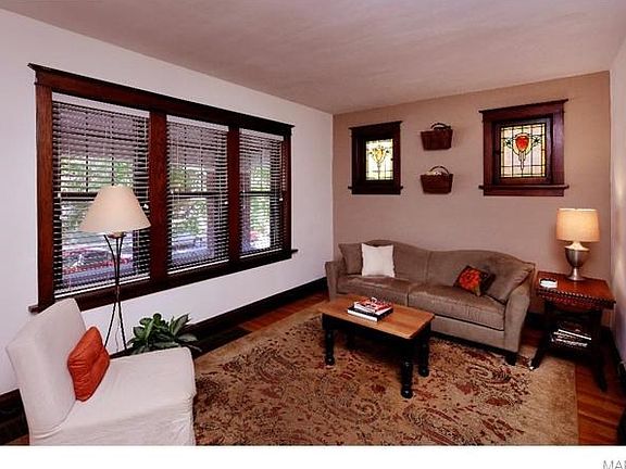 The living room has beautiful stained glass windows, original woodwork and wood floors.