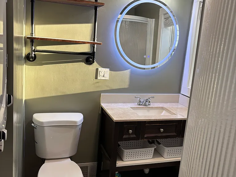 Bathroom: illuminated mirror, semi circle glass shower door, extra storage.