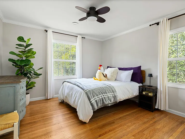 Light-filled and inviting this charming bedroom offers lush views, hardwood floors, and a soothing setup that's perfect for guests, kids, or a home office