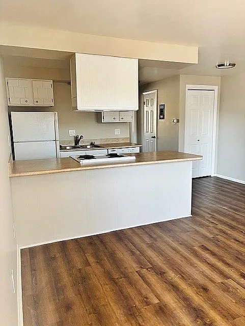 Inviting kitchen with sleek countertops, modern appliances, and elegant wood flooring in a bright, open layout.