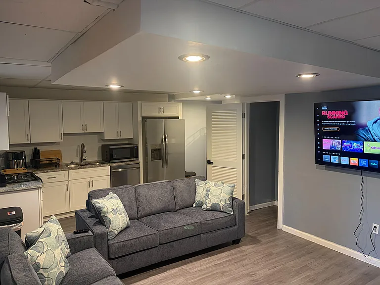 Open-concept living area connects to a full kitchen with ample cabinets, granite-look counters, and stainless fridge.