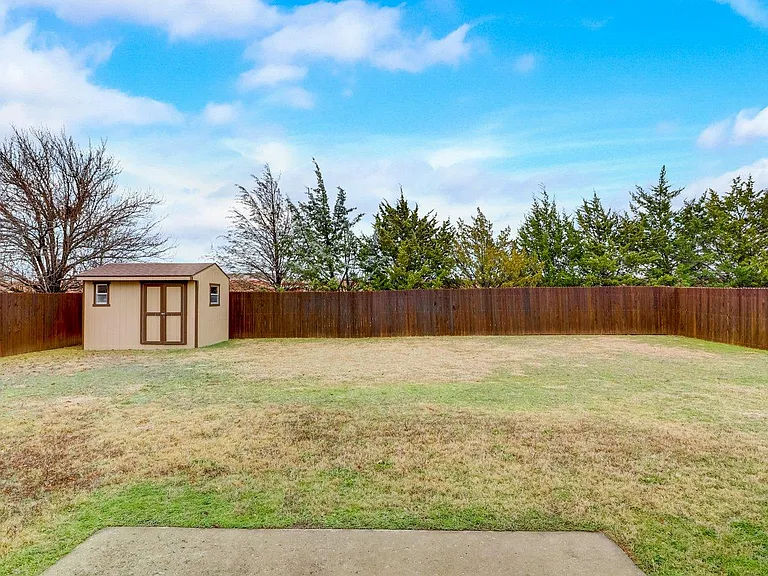 Private backyard with fresh stained fence and storage yard for all your garden tools