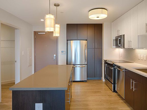 Brand-new kitchens feature stainless steel appliances, two-tone modern cabinets and quartz countertops