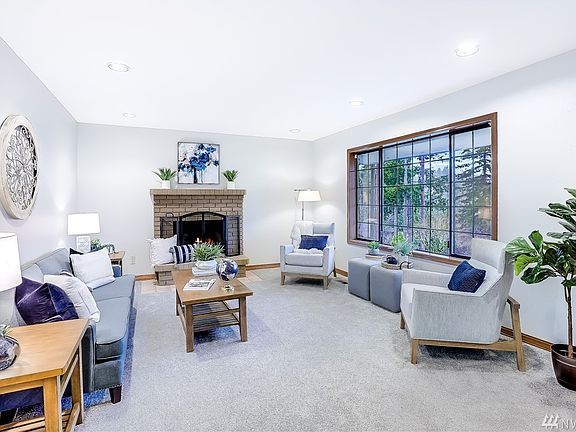 Formal living room with Lake Wilderness views, wood burning fireplace, new carpet and fresh paint.