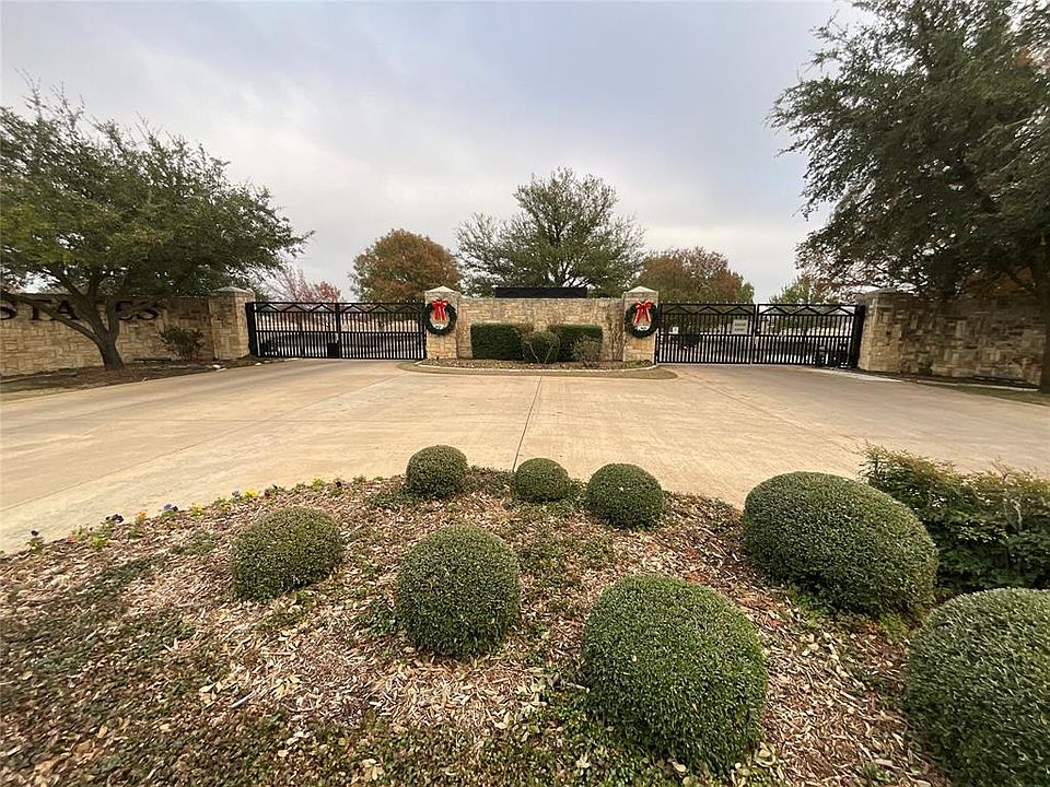 View of community featuring a gate and curved driveway