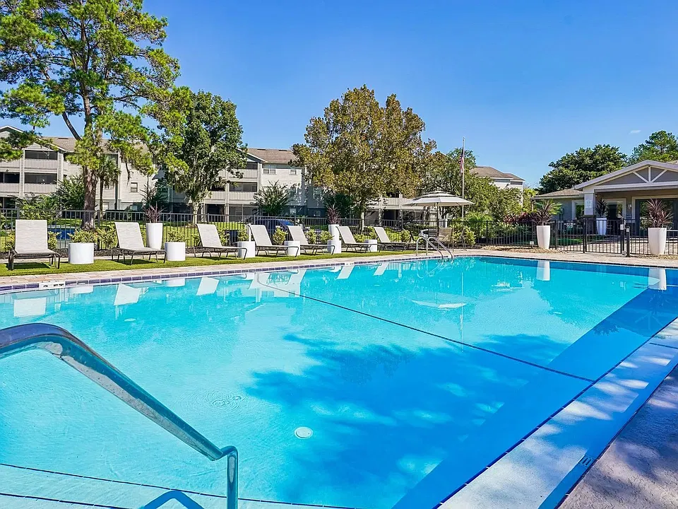 Escape the everyday at the resort-style pool featuring sparkling water, a spacious sundeck, comfortable lounge seating, and beautifully landscaped surroundings perfect for relaxing under the Florida sun.