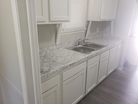 Kitchen will have new, bright white cabinets, new countertop, and a new laminated wood floor