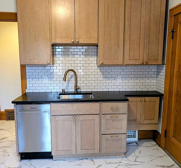 [UPPER UNIT]: Newly remodeled kitchen with stainless steel appliances, leathered granite countertops, solid wood cabinets, luxury vinyl tile flooring with Carrara Marble aesthetic, champagne gold fixtures