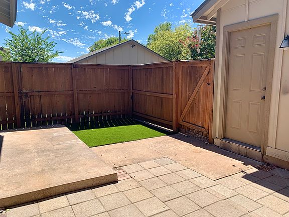 Paved back patio with artificial turf