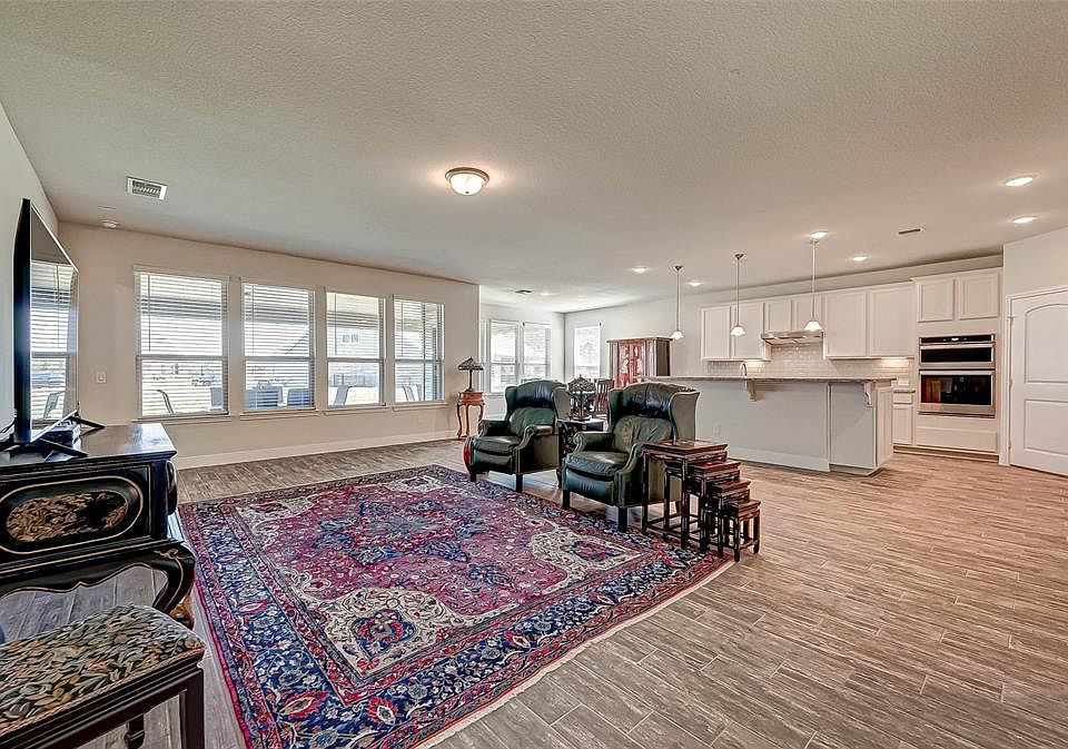 Stunning 1-story home situated in the heart of Del Webb, Sweetwater. Introducing the gathering room, kitchen and dining areas which are both stylish and comfortable with a wall of windows and wood-like tile flooring throughout. This angle shows-off t