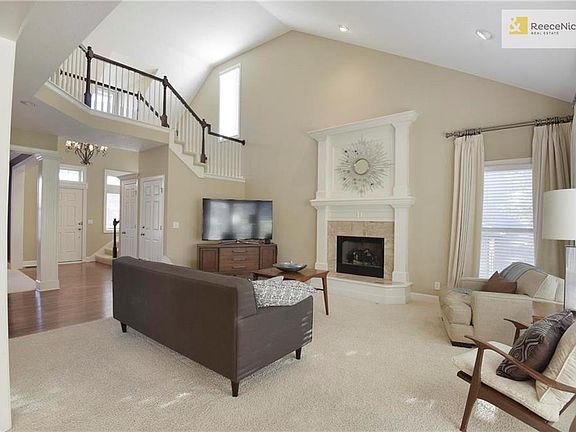 Living room with raised fireplace, soaring ceilings, and tons of light