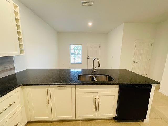 Large kitchen design. Featuring white cabinets and black granite counter tops.