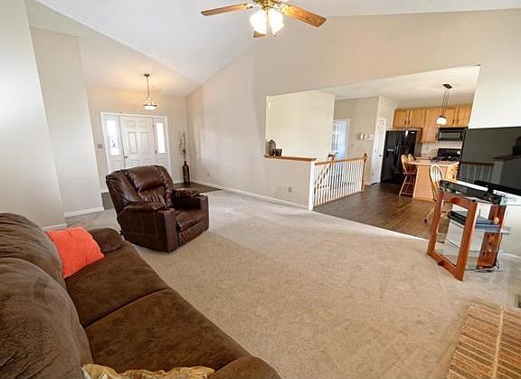 Great room with vaulted ceilings, fireplace and fan.