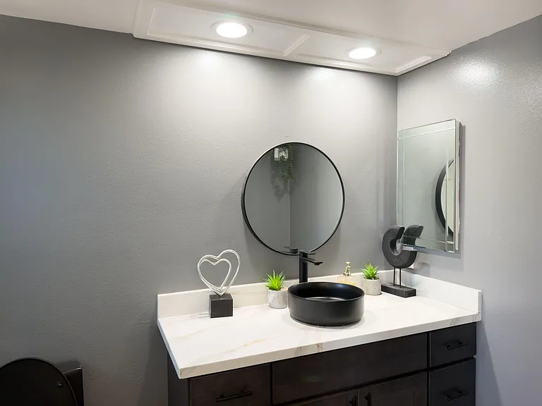 Updated bathroom vanity with a quartz-style countertop, vessel sink, and ample cabinet storage for daily essentials.