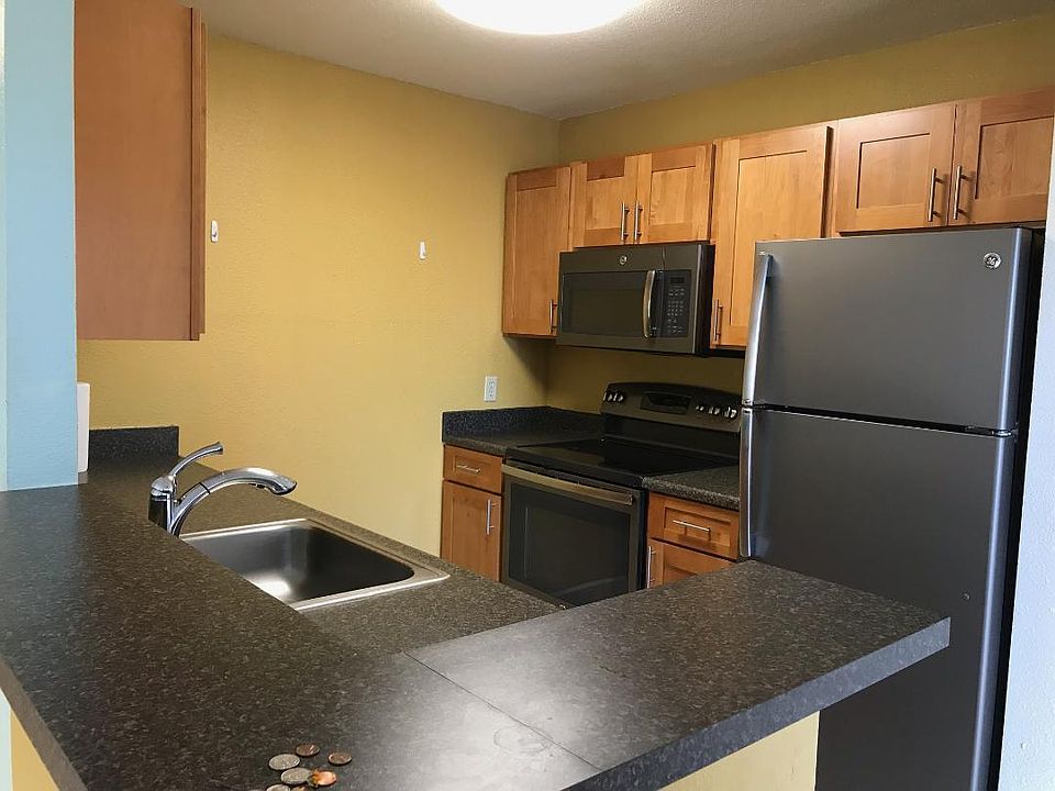 Kitchen area equipped with appliances - refrigerator, microwave, stove, and dishwasher.