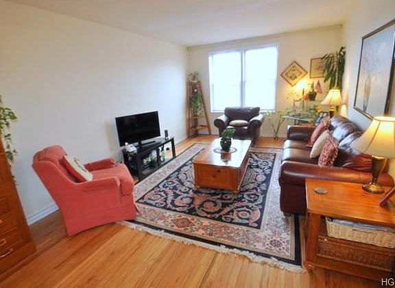 Large sunny living room with refinished hardwood floors.