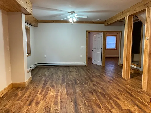 view of livingroom. In the back are the two bedrooms. To the right is a bathroom and a kitchen