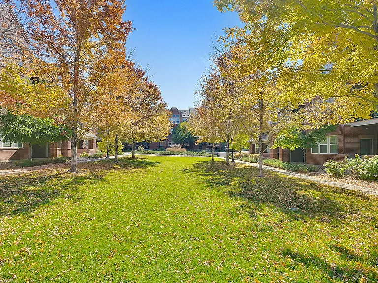 Charming autumn landscape featuring lush green lawns and vibrant foliage in a serene apartment community setting.
