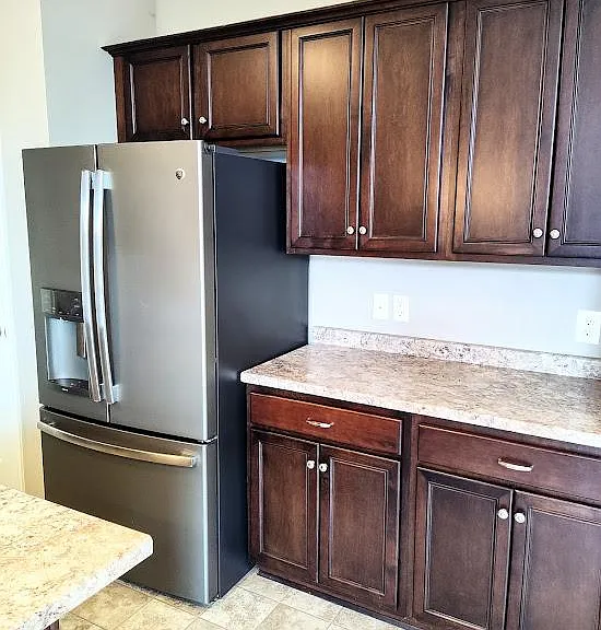 The kitchen features a stainless refrigerator and lots of countertop space and cabinetry.
