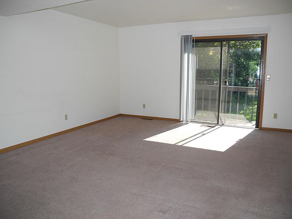 Spacious living room features patio door to rear balcony