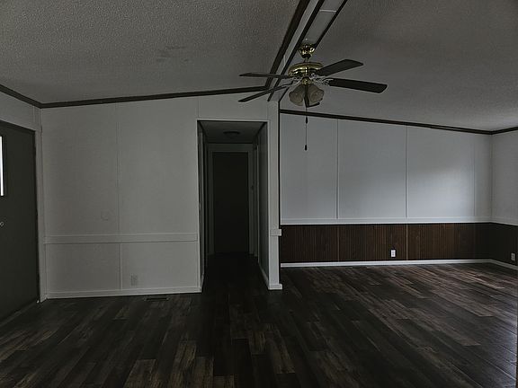 Large living room/family room with ceiling fan. Has brand new vinyl plank flooring, brand new vinyl windows, brand new trim, freshly painted.
