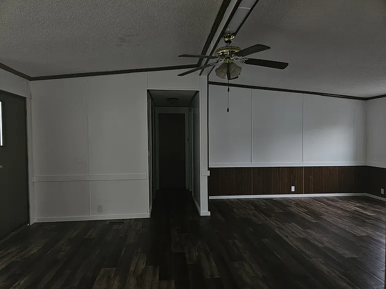 Large living room/family room with ceiling fan. Has brand new vinyl plank flooring, brand new vinyl windows, brand new trim, freshly painted.