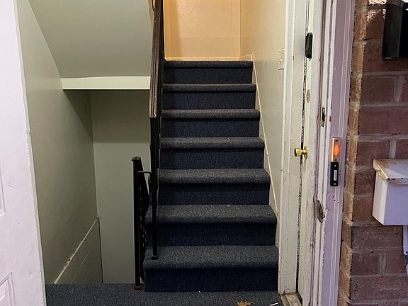 Steps from the front porch heading upstairs to the unit and downstairs to the basement.