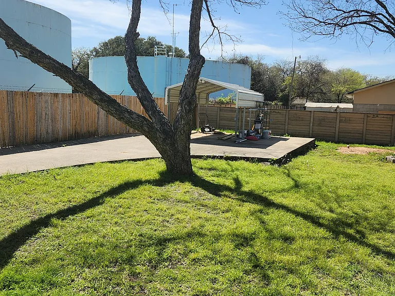 large fully fenced yard with 2 drvie through gates and 2 driveways. multiple covers areas