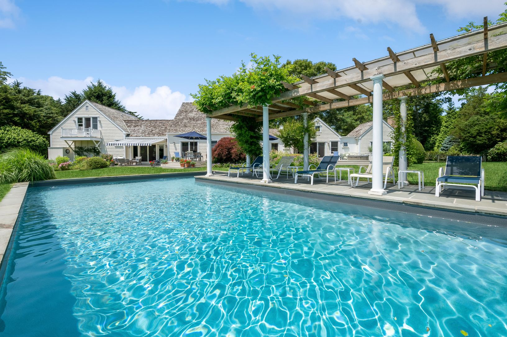 The heart of the property, poolside, beautiful gardens, music by deck, hot tub, pool, and court