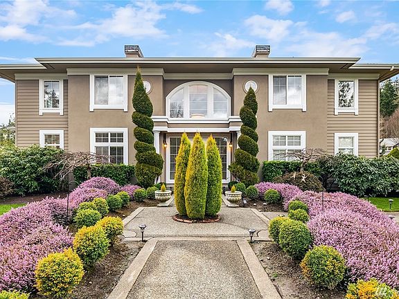Professional landscaping elevates this exquisite entrance. 