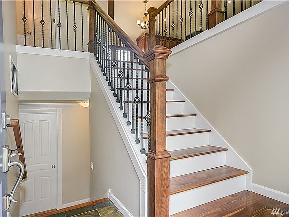 Beautiful iron railing with craftsman wood posts, fine acacia wood flooring & fresh white trim.