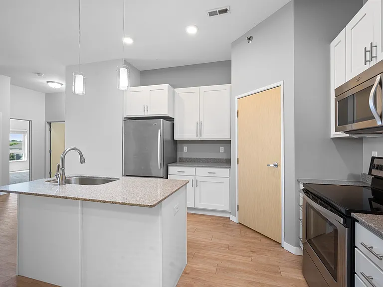 Modern kitchen with sleek stainless steel appliances, elegant granite countertops, and stylish pendant lighting. Modern kitchen with sleek stainless steel appliances, elegant granite countertops, and stylish pendant lighting.
