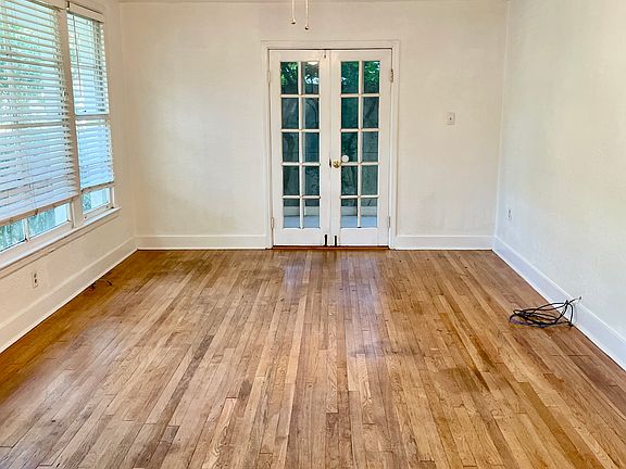 Large living room with hardwood floors and a large attached screened-in sunroom that can also be used as an office.