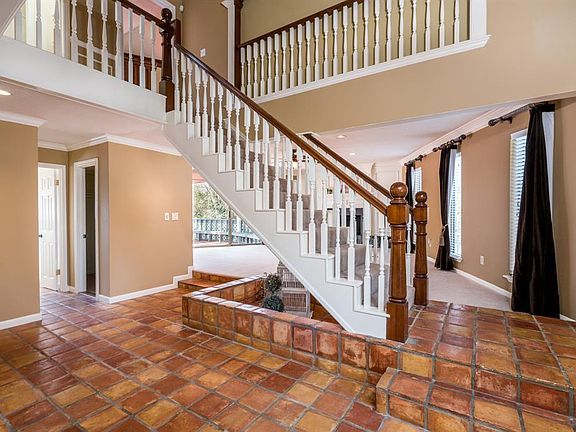 Welcome home! Electronic door locks for convenience, pretty Rustique Cotto porcelain floors in the entry. This is one of 2 stair cases leading to the second story. Step up into the formal living room, just off the entry.