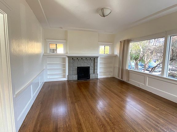 Living Room with Picture Window and Newly Refinished Hardwood Floor Through Out the House