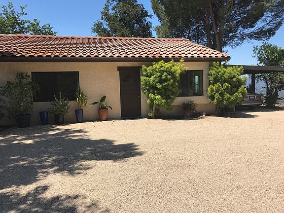 Guesthouse front with covered parking on right.
