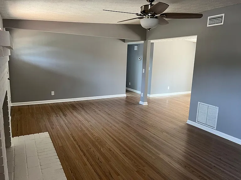 Large living room with Fireplace new fan and floors. New central heat and air conditioning.