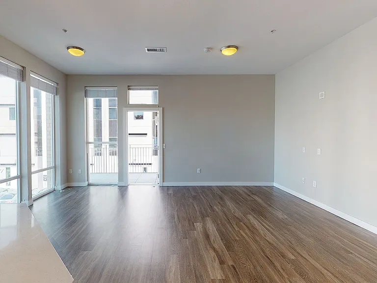 Apartment living room with wood-style flooring with balcony or patio.