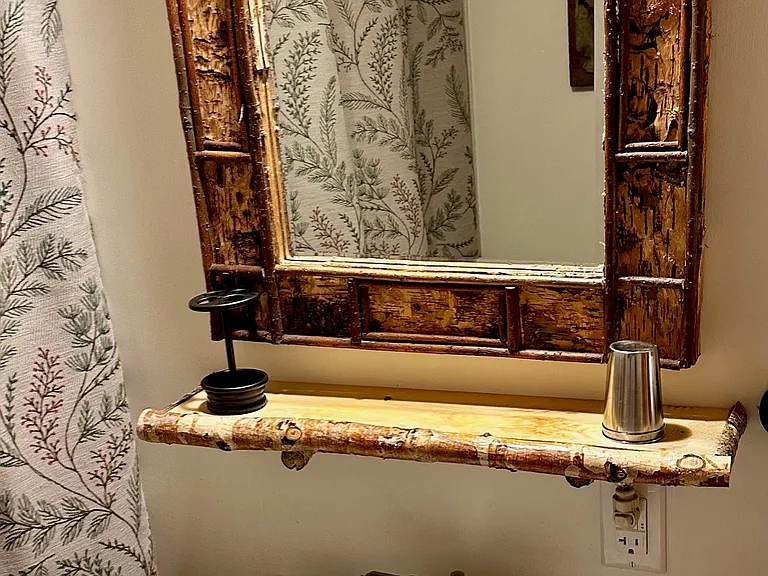 Black Forest Decor Adirondack birch bark frame mirror with twig shelf and sink.