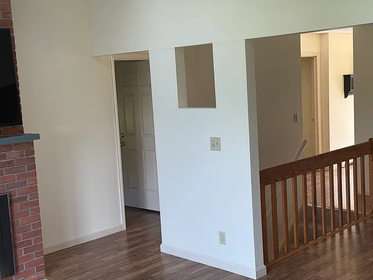 Cross section from living room, dining room, stairs to lower level. Also in the photo is a door to the master bedroom just right of the fireplace and you can see the entrance to the 2nd upstarts bedroom.