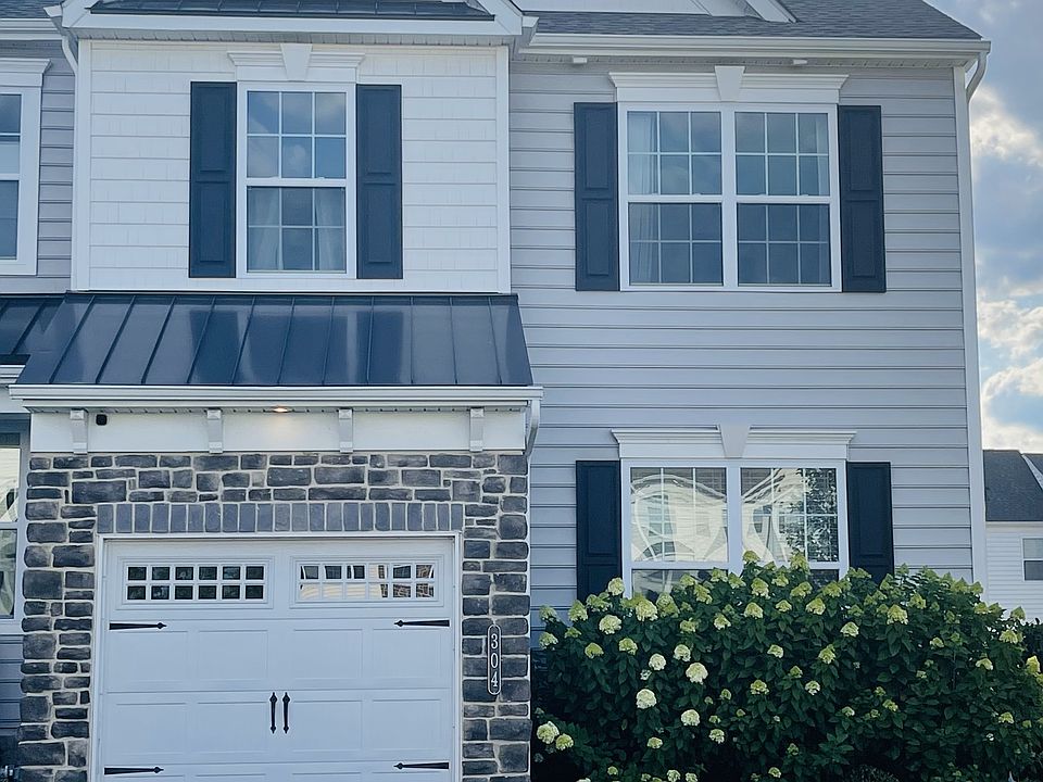 Facade showing attached garage and 2-car driveway.